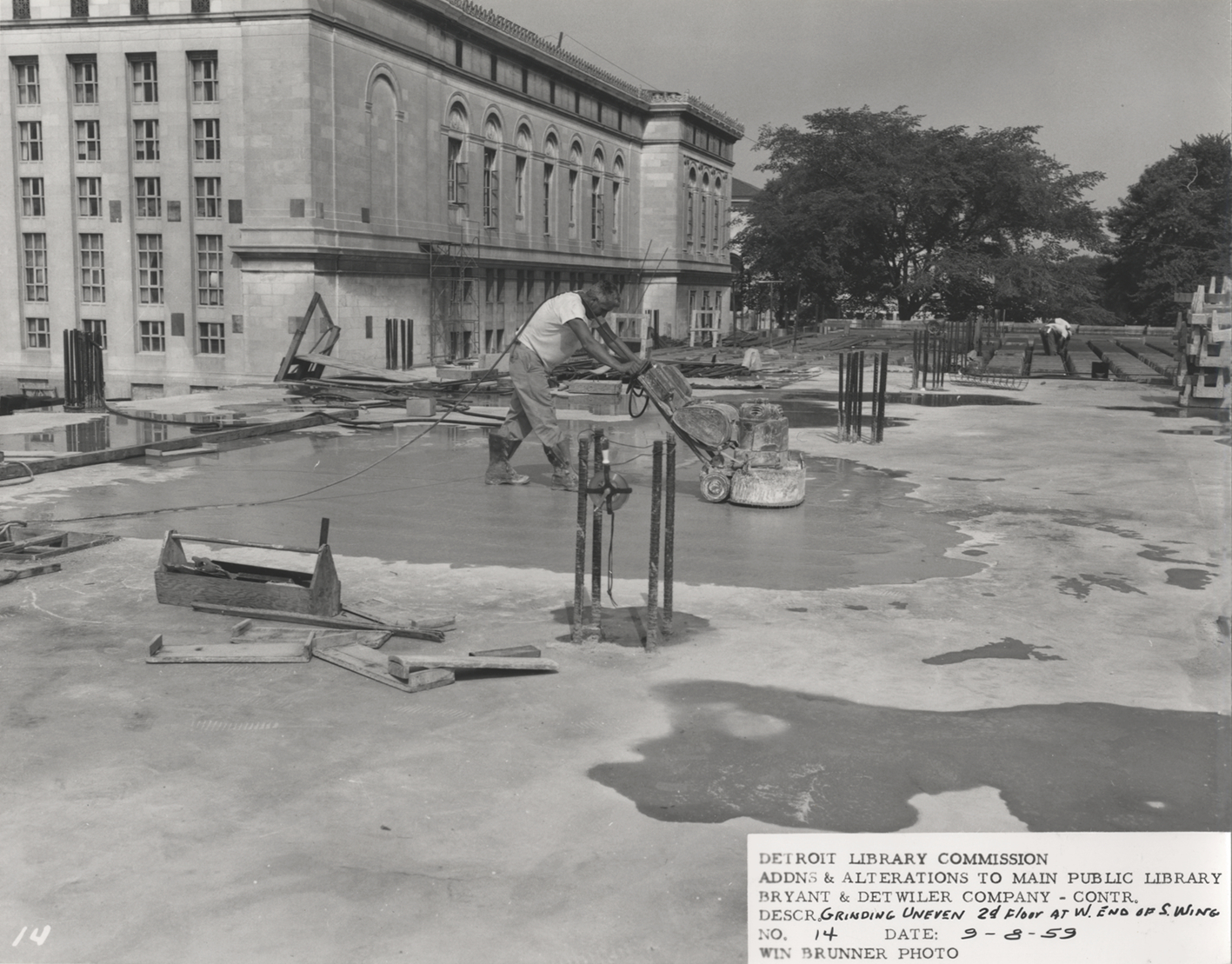 Workman grinding concrete floor, Main Library