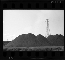 Piles of dirt and pylons for power lines