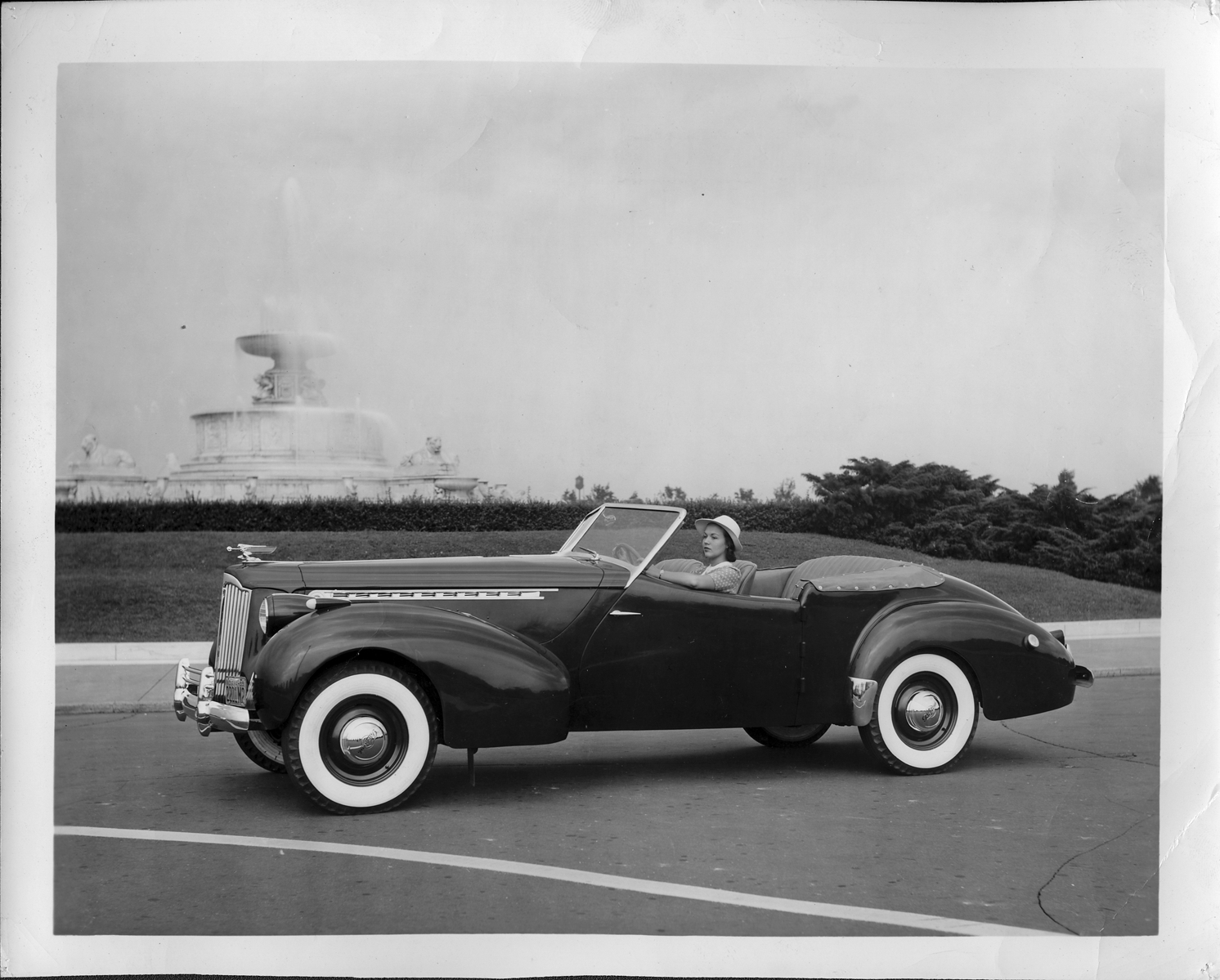 Woman posing in 1940 Packard convertible victoria by Scott fountain