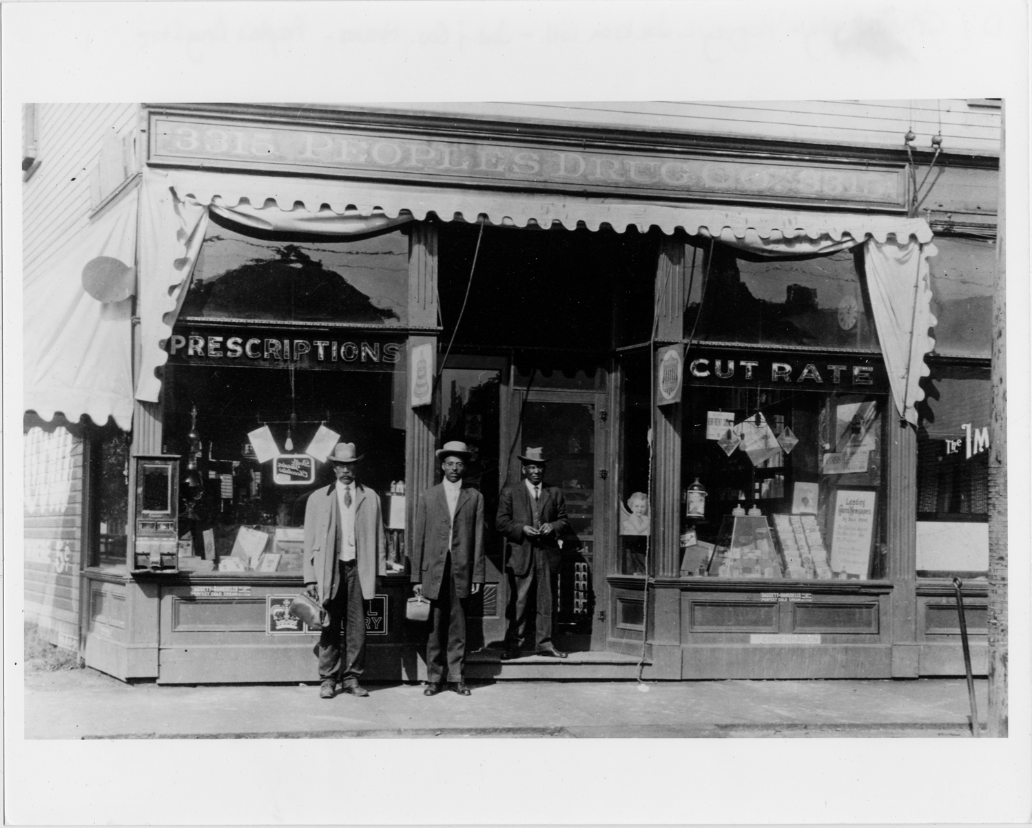 Men posing in front of the People's Drug Co.