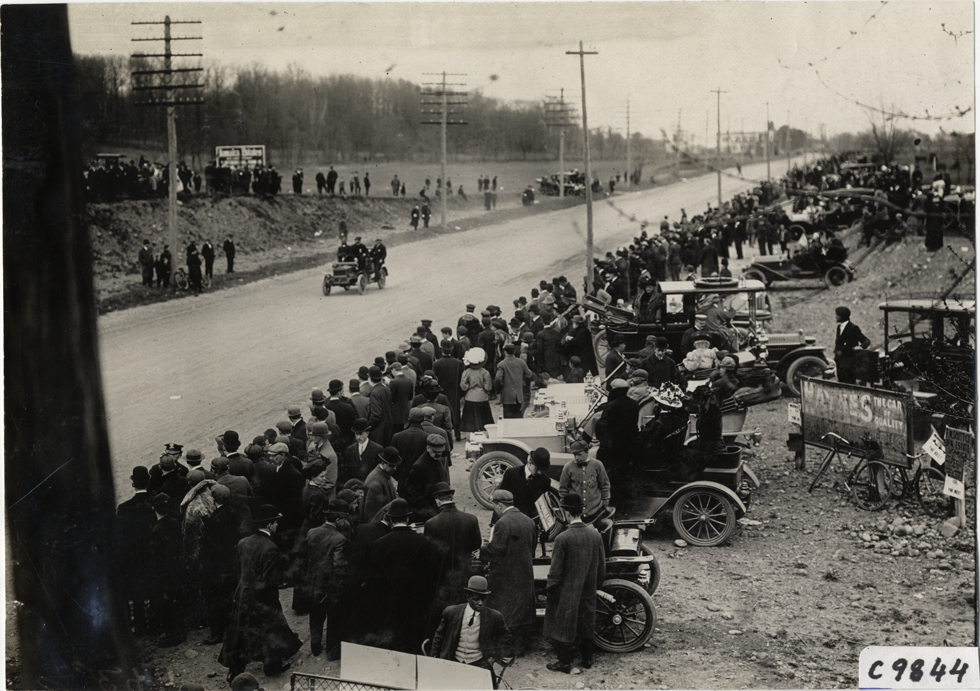 Spectators watching racecar, 1909 Fort George Hill Climb
