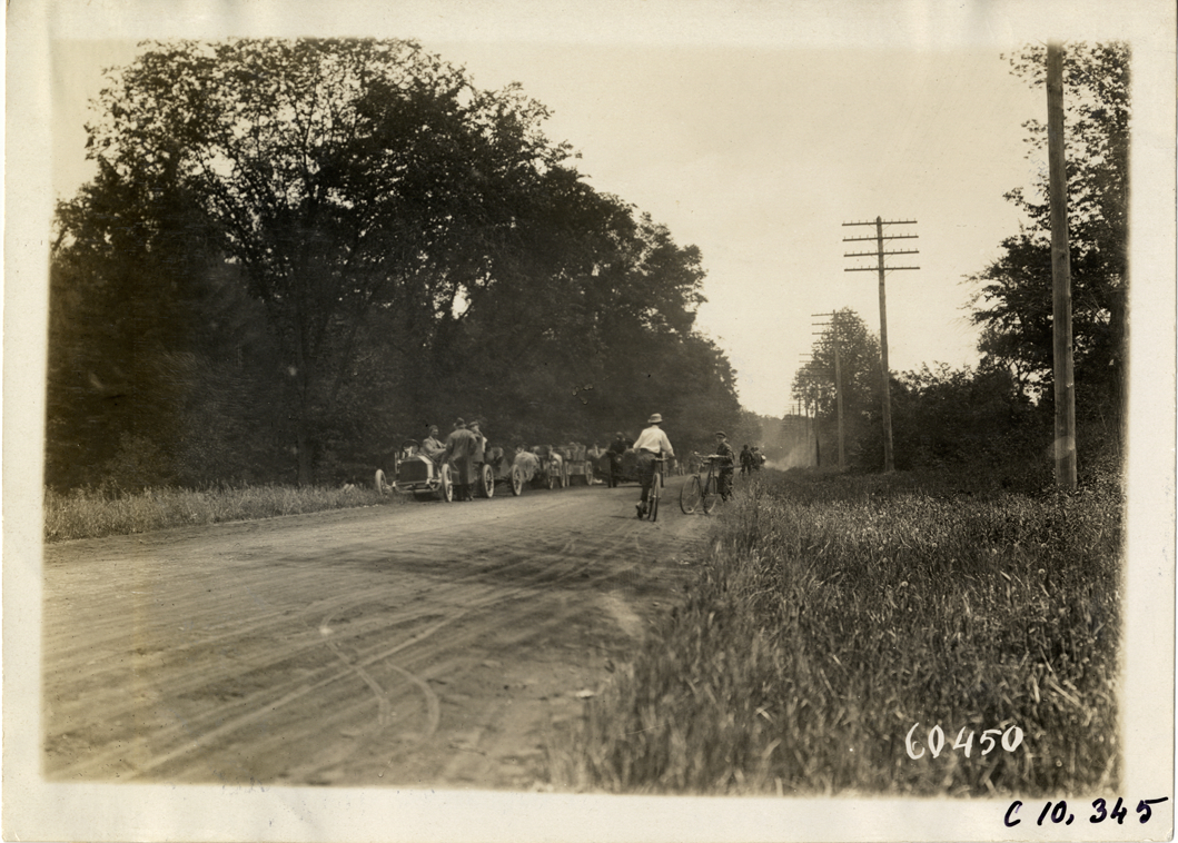 Racecars and bicyclists on roadside, 1910 White Plains Hill Climb