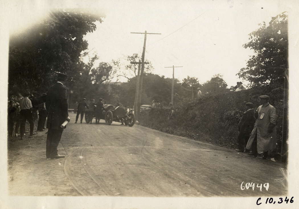 Men gathering around racecar in road, 1910 White Plains Hill Climb