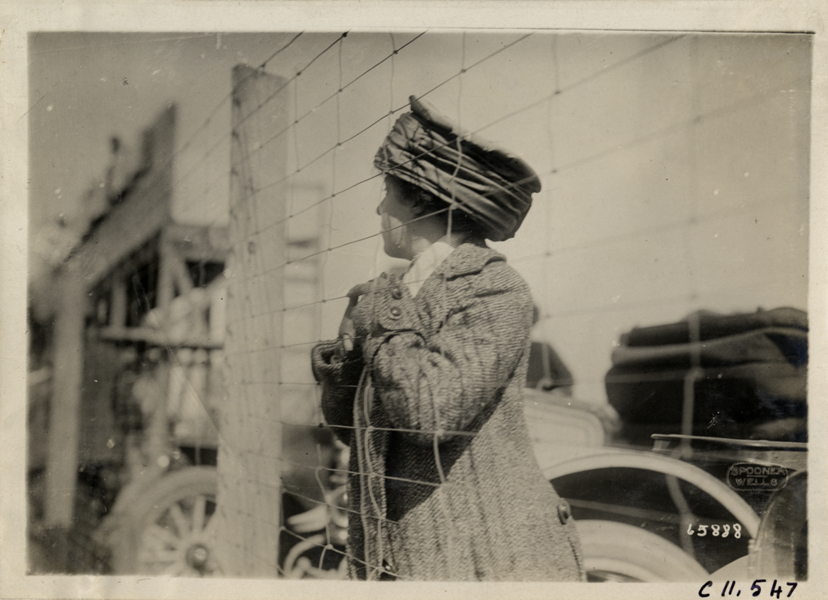 Woman standing behind fence, Atlanta Speedway