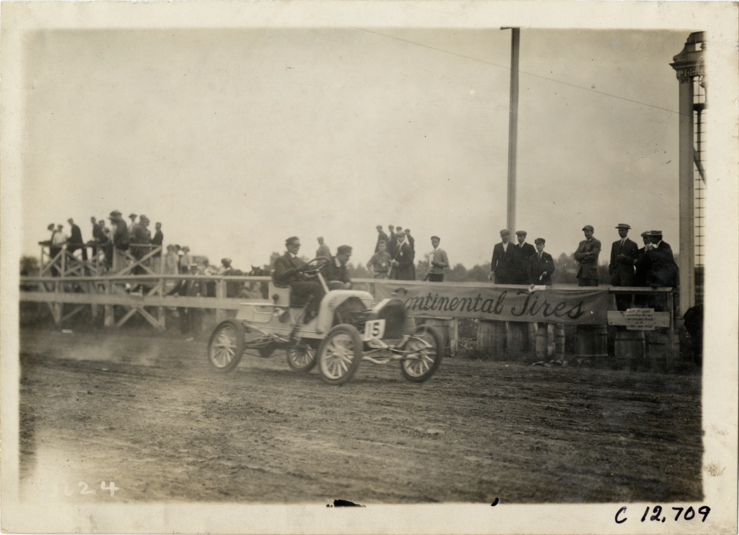 Driver and passenger in racecar, 1910 Empire City races