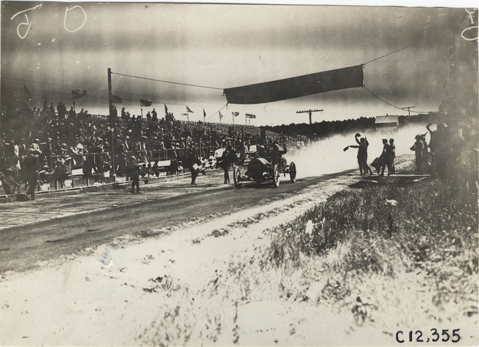 Racecar crossing finish line, 1909 Crown Point races