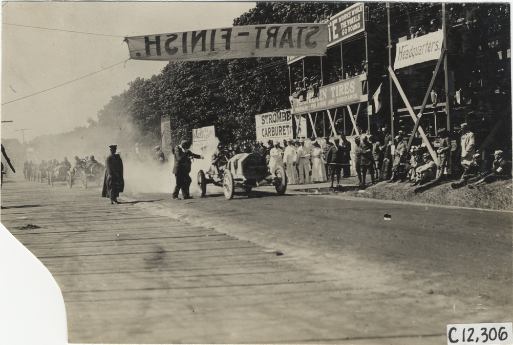 Racecar parked in front of spectators in stands, 1909 Crown Point races