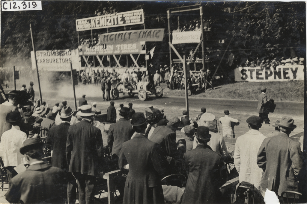 William Bourque in Knox racecar parked in front of stands, 1909 Crown Point races