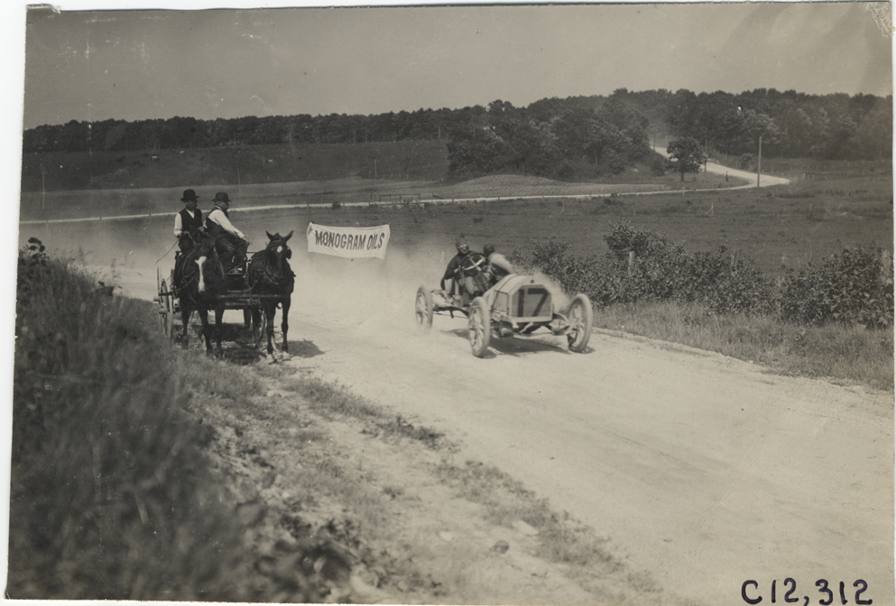 Racecar passing horse-drawn wagon, 1909 Crown Point races