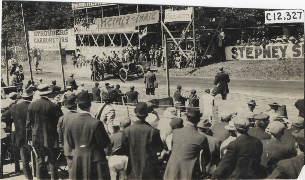Racecar parked in front of spectators in stands, 1909 Crown Point races
