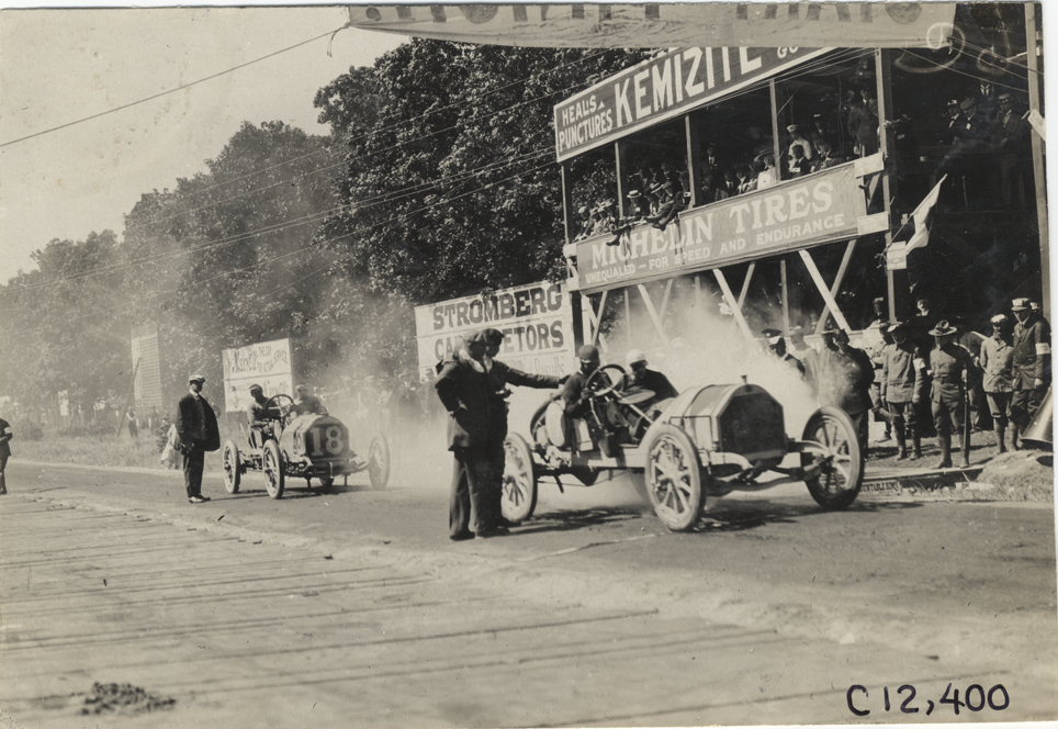 Racecars parked in front of stands, 1909 Crown Point races