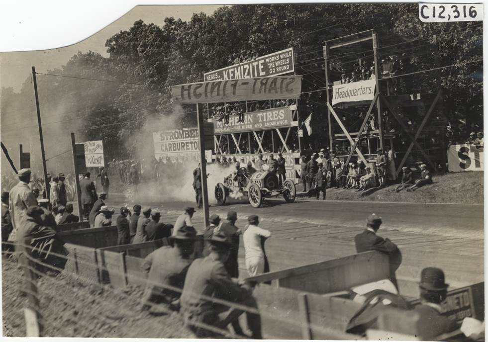 Racecar parked in front of spectators in stands, 1909 Crown Point races