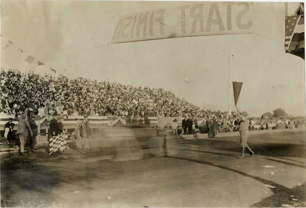 Racecar crossing finish line, 1908 Grand Prize races