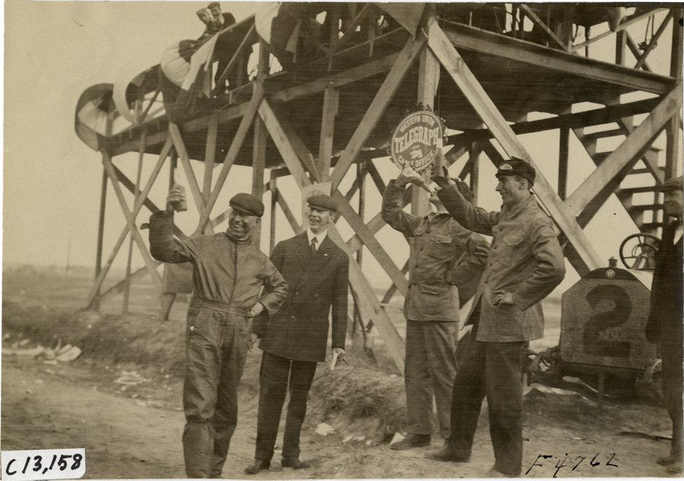 Men holding beverage bottles, 1908 Grand Prize races