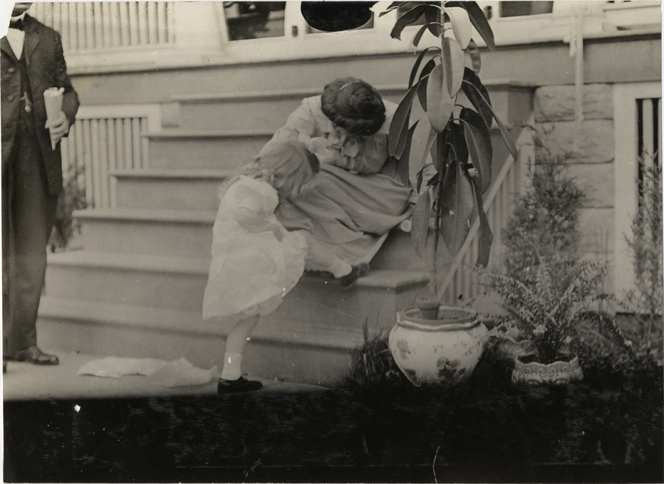 Woman examining girl's knee, 1908 Grand Prize races