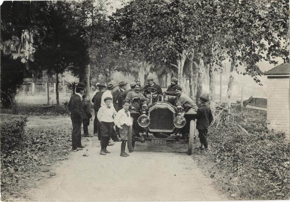 Men and boys surrounding racecar, 1908 Grand Prize races