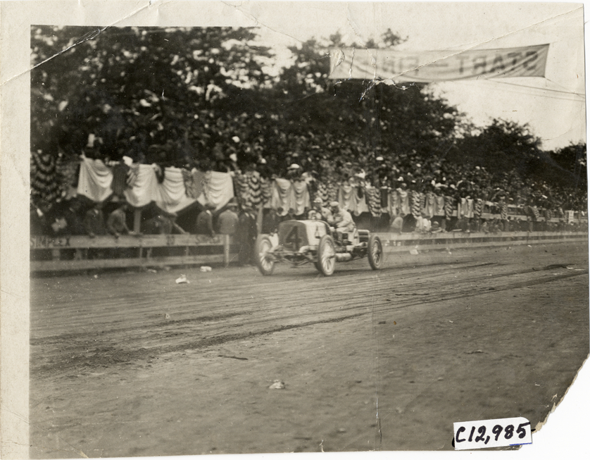 Racecar passing spectators in bleachers, 1910 Fairmount Park races