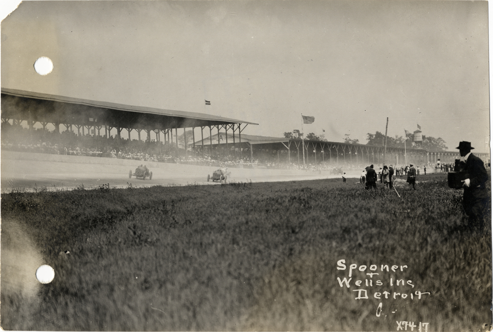 Sunbeam and Mercer racecars racing past grandstand, 1913 Indianapolis 500 automobile race