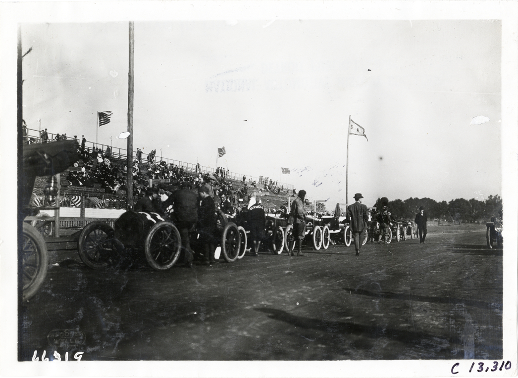 Racecars lined up on side of track, 1910 Grand Prize races