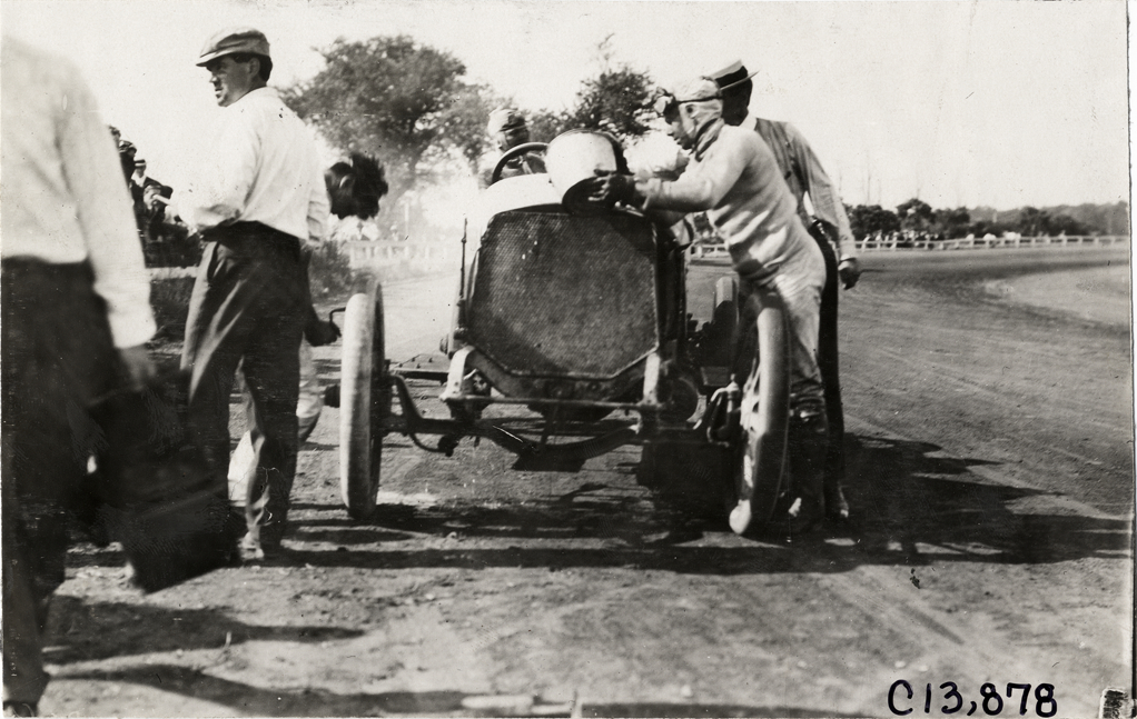 Mechanic filling racecar radiator, 1908 Long Branch races