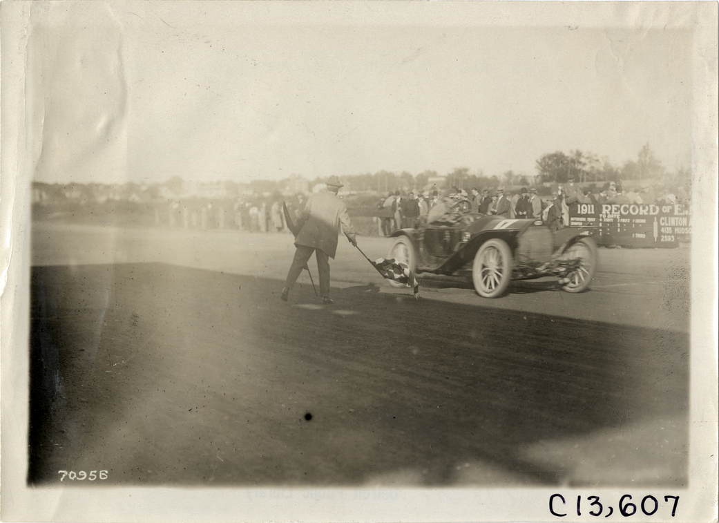 Racecar crossing finish line, 1911 Guttenberg races