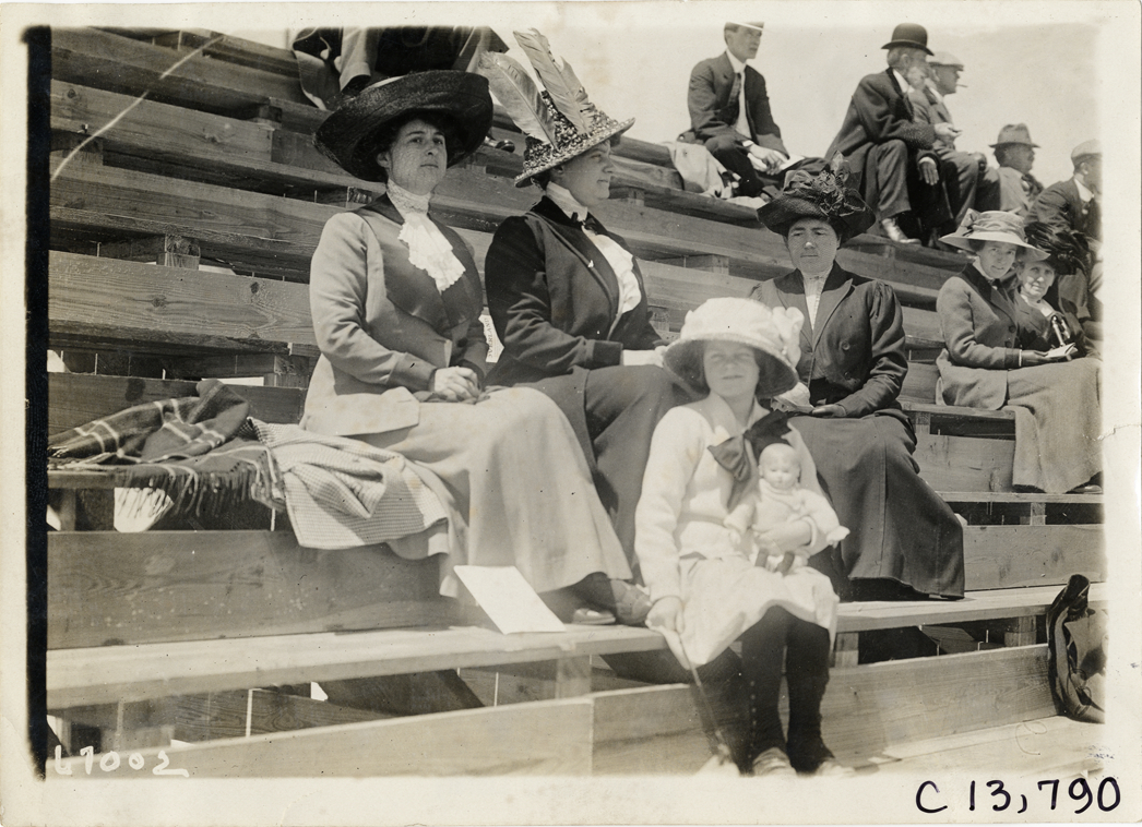 Women and girl sitting on bleachers, 1911 Jacksonville automobile races