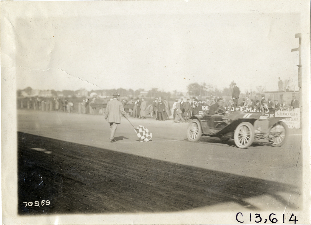 Racecar crossing finish line, 1911 Guttenberg races