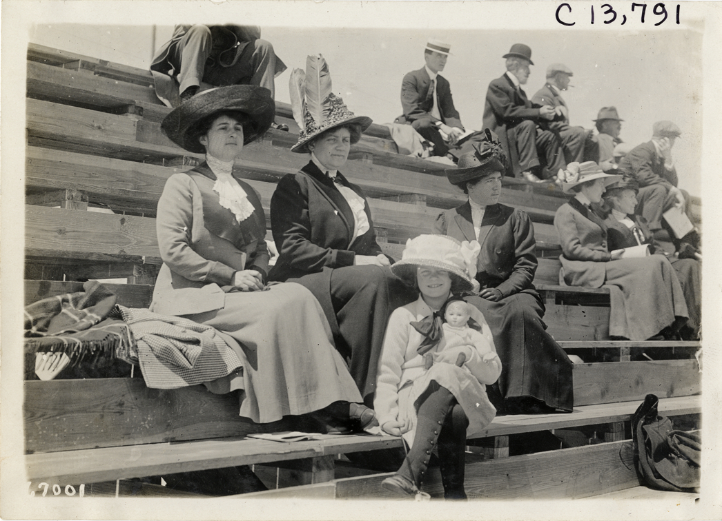 Women and girl sitting on bleachers, 1911 Jacksonville automobile races