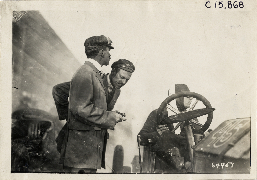 Officials standing next to racecar, 1910 Vanderbilt Cup races