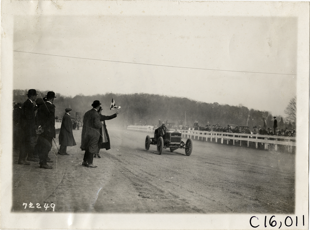 Racecar crossing finish line, 1911 White Plains races