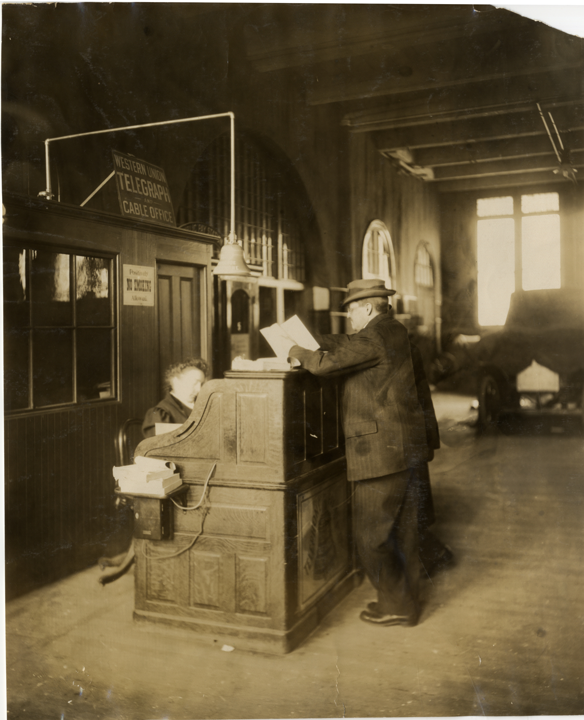 Men standing at Western Union desk, 1909 Boston Auto Show