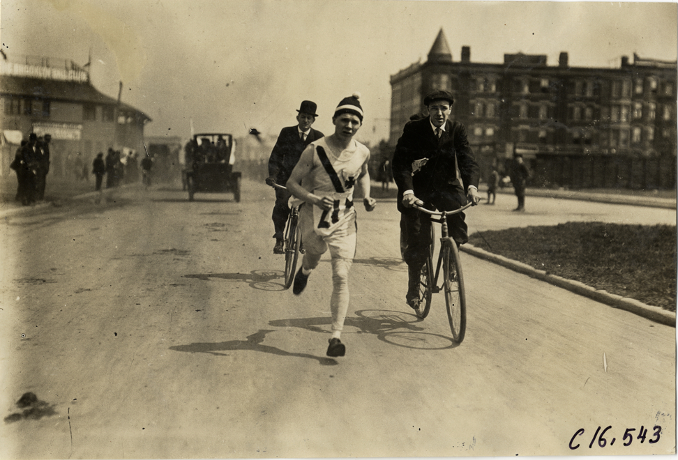 Bicyclists following runner in marathon race