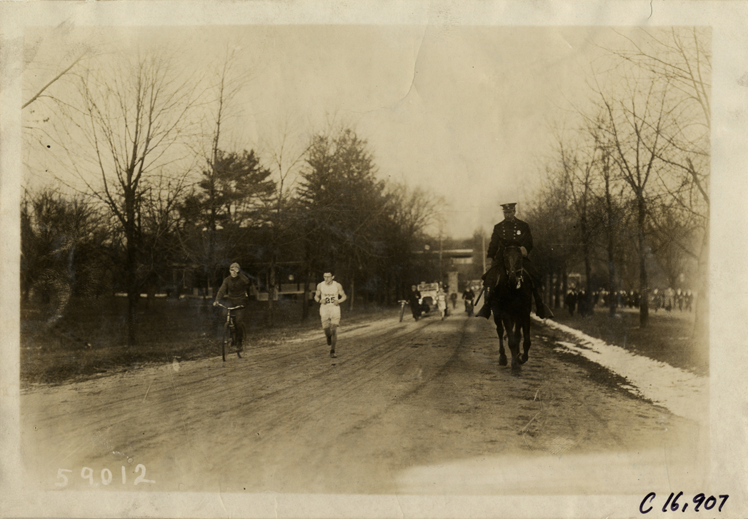 Bicyclist following marathon runner