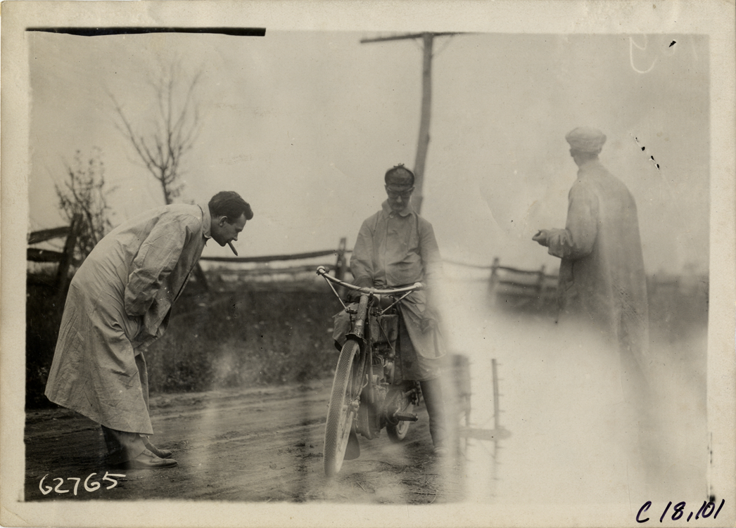 Official looking at motorcycle, 1910 Federation of American Motorcyclists Endurance Run