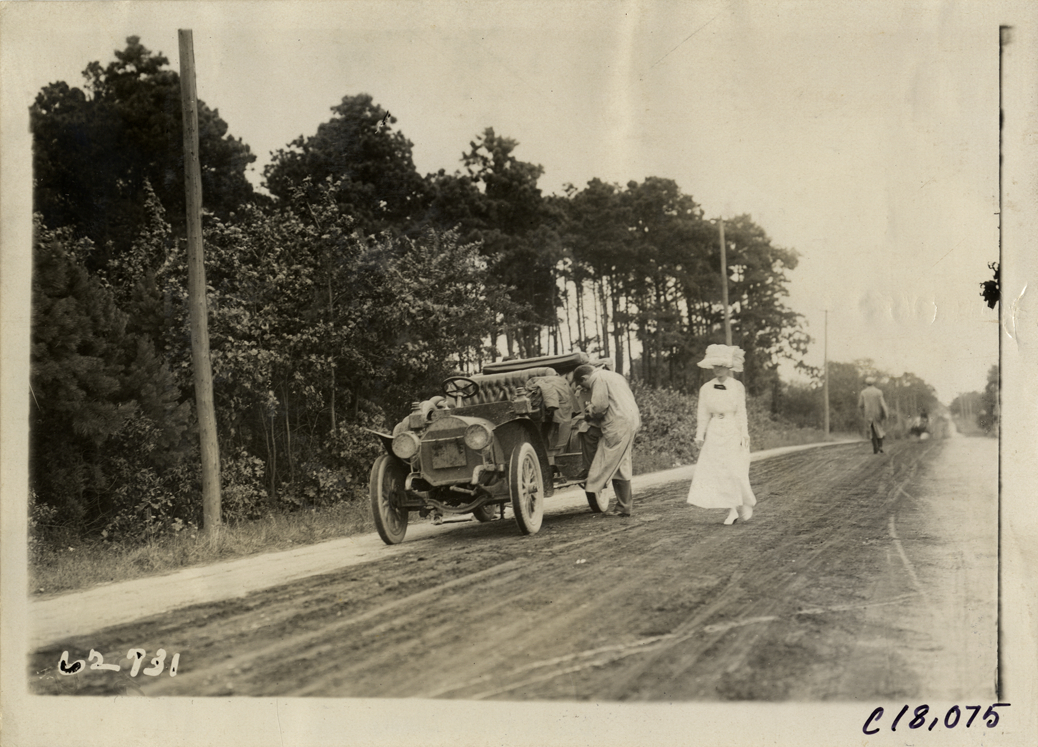 Official with automobile, 1910 Federation of American Motorcyclists Endurance Run