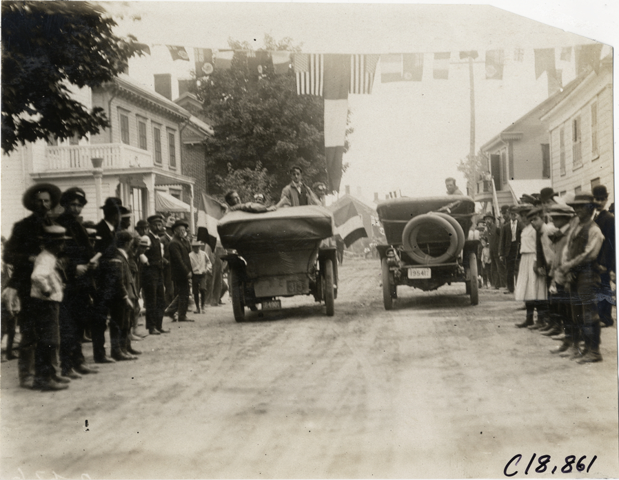 Automobiles parked under flags, 1906 Glidden Tour