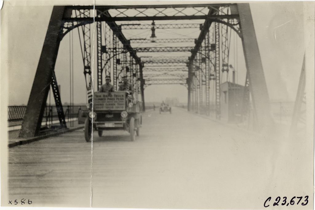 Motorists in Rapid truck crossing bridge, 1910 Glidden Tour