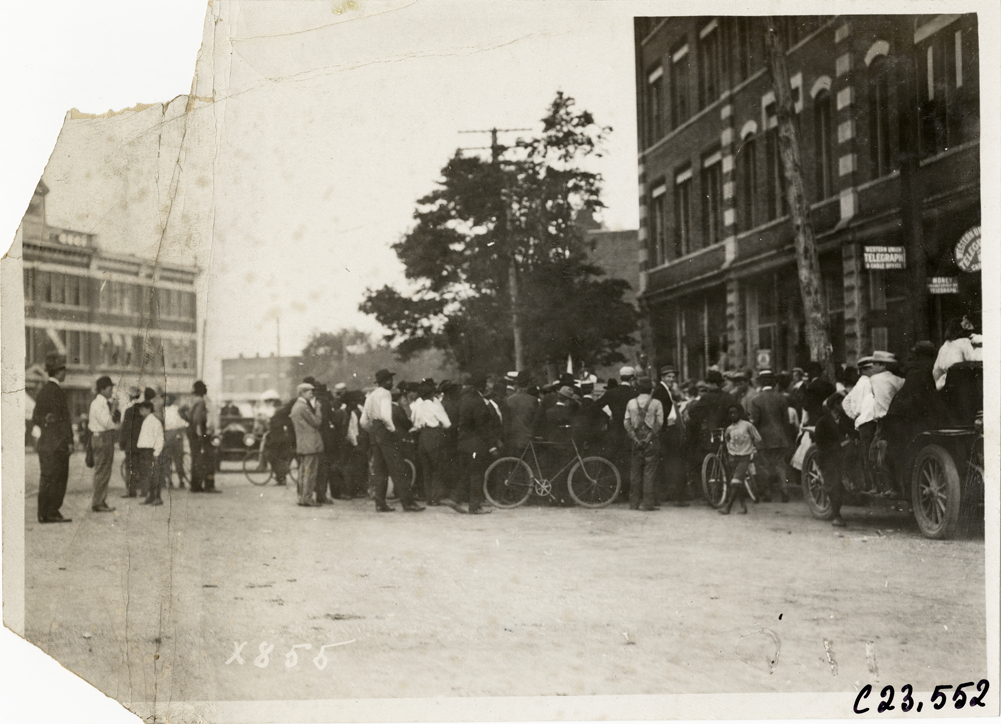 Crowd surrounding automobile in street, 1910 Glidden Tour