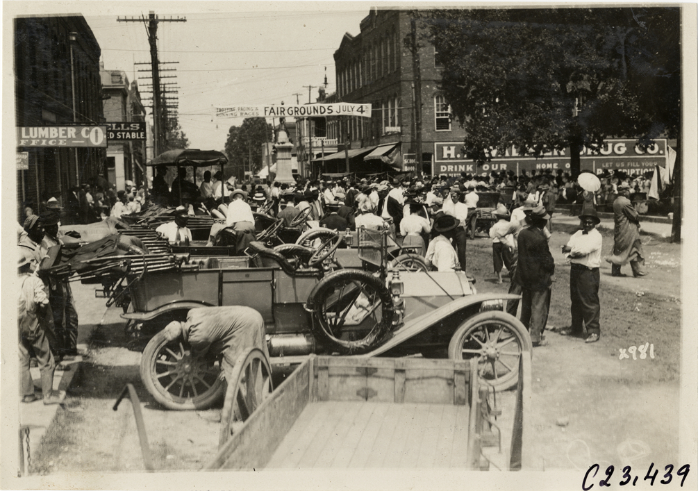 Crowd surrounding automobiles in street, 1910 Glidden Tour