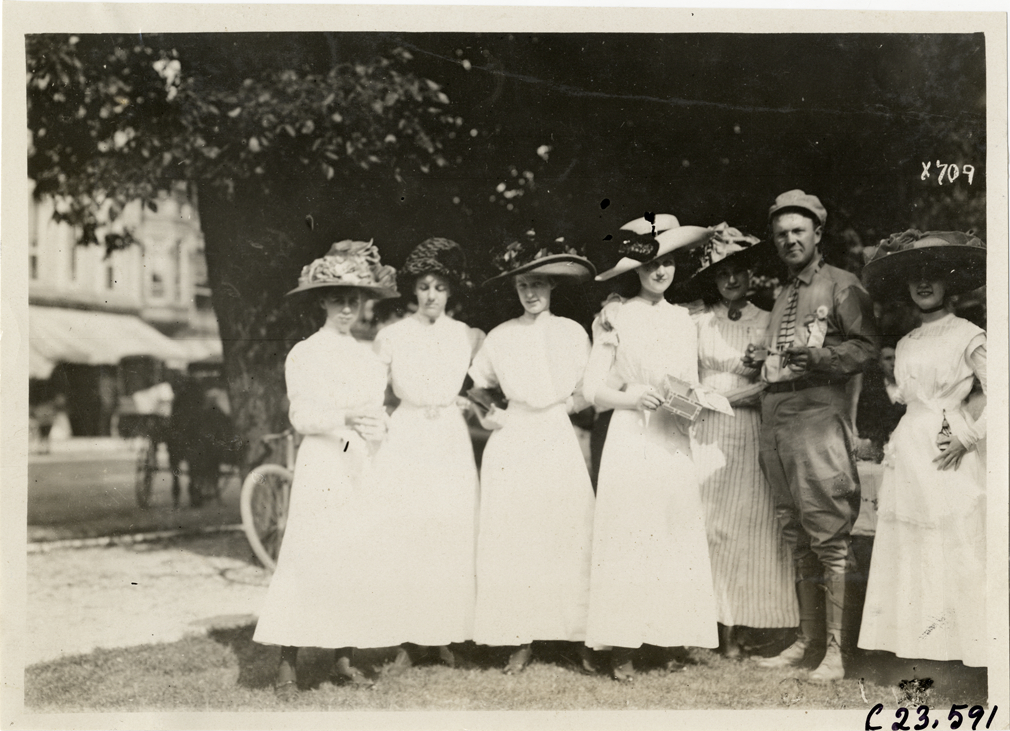 Women posing with motorist, 1910 Glidden Tour