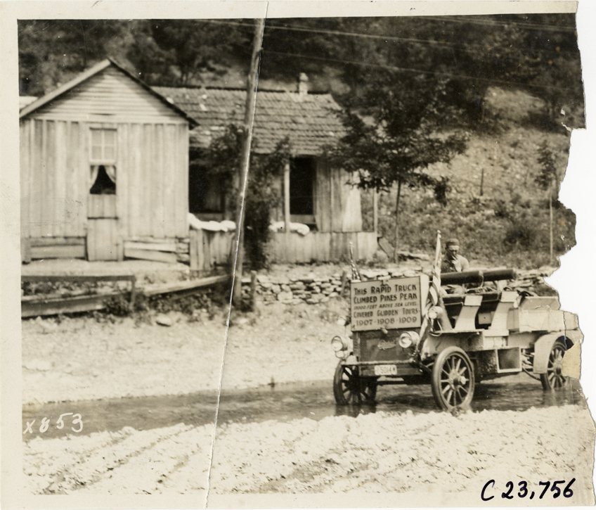 Motorists in Rapid truck traveling on flooded rural road, 1910 Glidden Tour