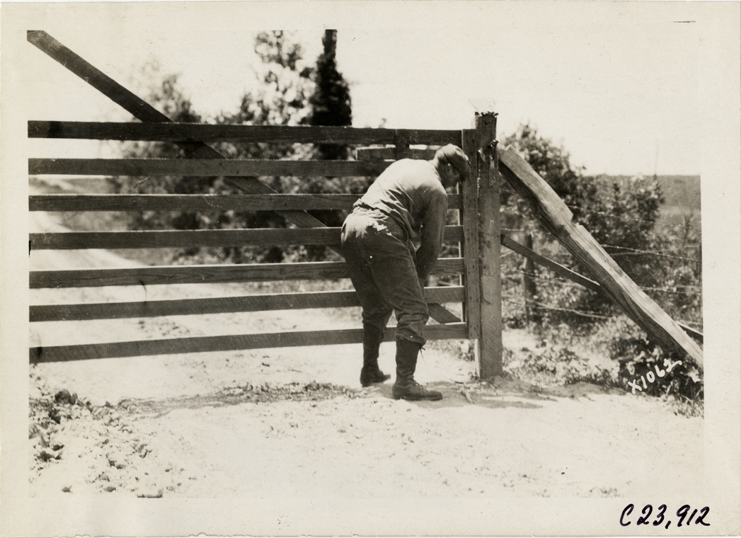 Motorist closing gate, 1910 Glidden Tour