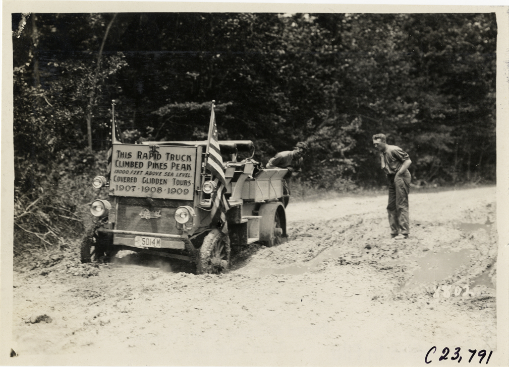 Motorists looking at Rapid truck stuck on muddy road, 1910 Glidden Tour
