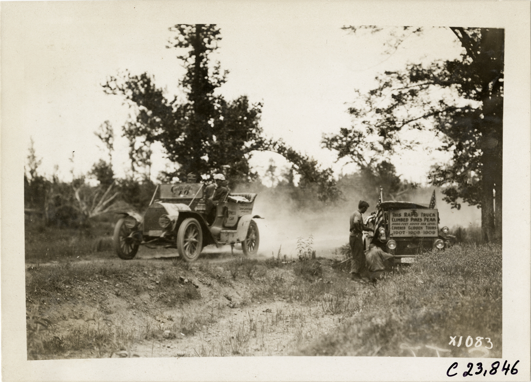 Motorists in Cutting automobile passing Rapid truck on roadside, 1910 Glidden Tour