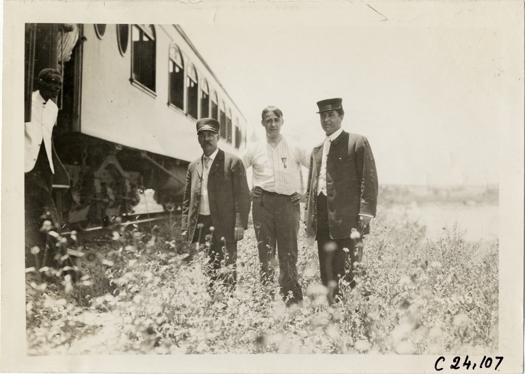 Motorist posing with railroad employees, 1910 Glidden Tour