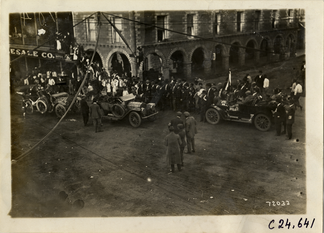 Crowd looking at automobiles in street, 1911 Glidden Tour