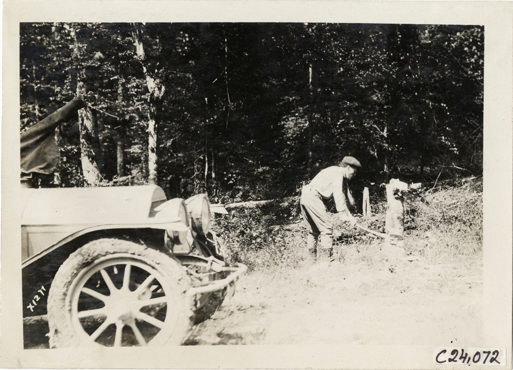 Motorist chopping tree, 1910 Glidden Tour