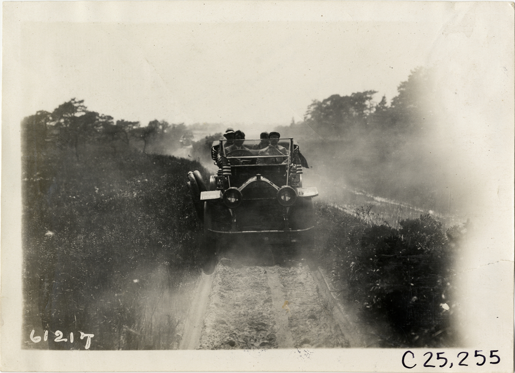 Motorists in automobile traveling on rural road, 1910 Montauk Point Reliability Run