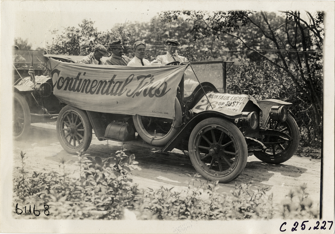 Motorists in automobile draped with Continental Tires banner, 1910 Montauk Point Reliability Run