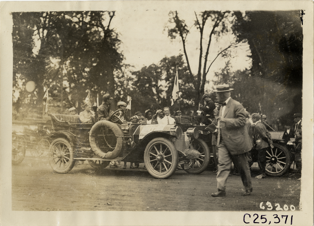 Motorists in automobiles parked in street, 1910 Munsey Historic Tour